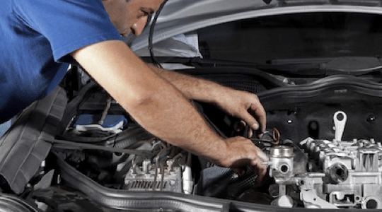mechanic checking under the hood of a car